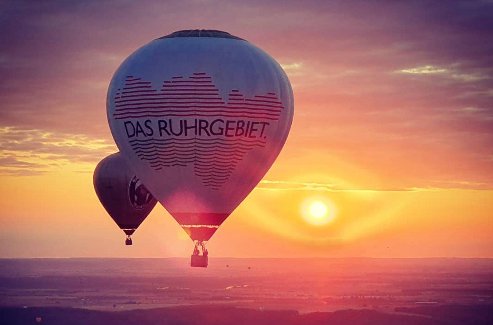 Heißluftballon mit dem Schriftzug „Das Ruhrgebiet“ vor dem Sonnenuntergang
