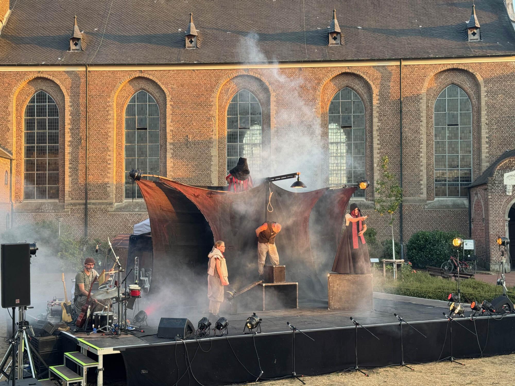 Szene aus „Till Eulenspiegel“ mit Nebelschwaden vor den Fenstern der Abteikirche