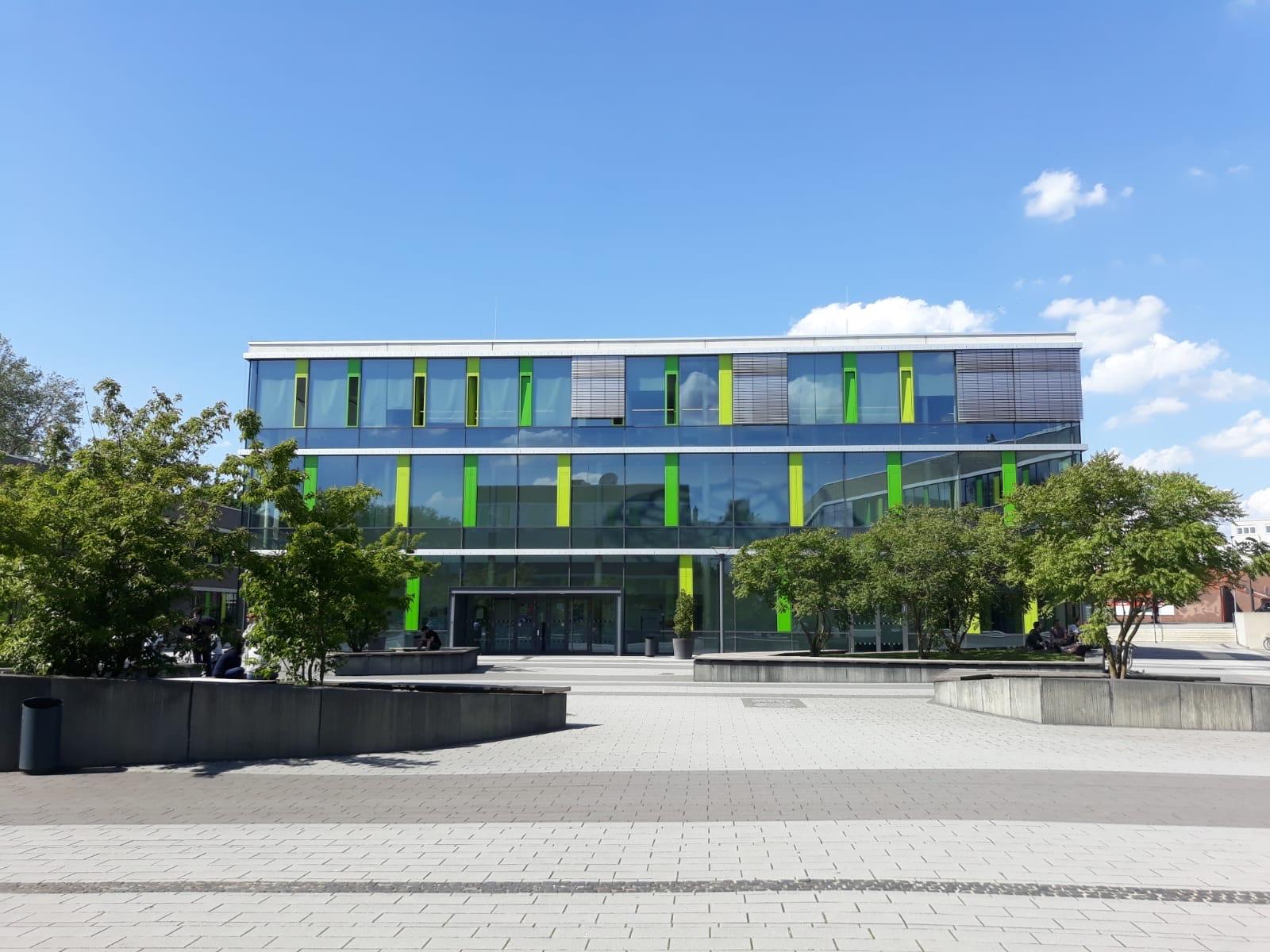 Glasfassade mit grünen Akzenten eines Gebäudes am Campus Kamp-Lintfort der Hochschule Rhein-Waal bei blauem Himmel